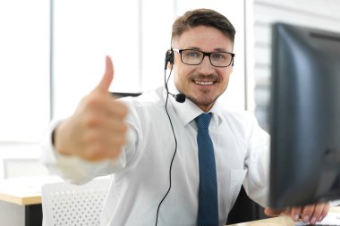 Mutlu çağrı merkezi gülümseyen işadamı müşteri desteği danışma hizmetleri ajanı çağrı merkezindeki kablosuz mikrofon ve bilgisayarla çalışıyor.