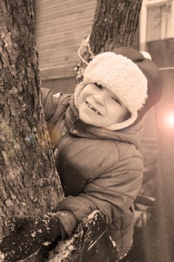 Kışın ağaçta komik çocuk.