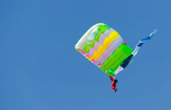Parachutiste sur fond bleu ciel avec parachute coloré — Photo