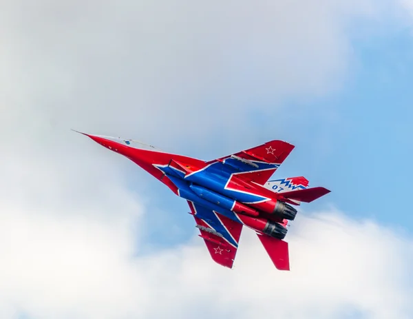 El equipo acrobático MiG-29 Swifts vuela contra el cielo azul y las nubes . — Foto de Stock