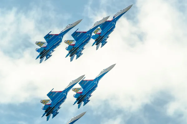 Die Su-27-Kampfflugzeuge gewinnen vor blauem Himmel und Wolken an Höhe. — Stockfoto