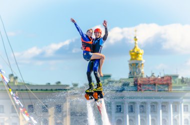 Devochkoy mavi gökyüzü, bulutlar ve saraylar St. Petersburg sahildeki karşı taraftan ile atlet flybarless.