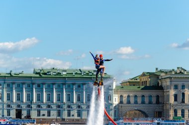Devochkoy mavi gökyüzü, bulutlar ve saraylar St. Petersburg sahildeki karşı taraftan ile atlet flybarless.