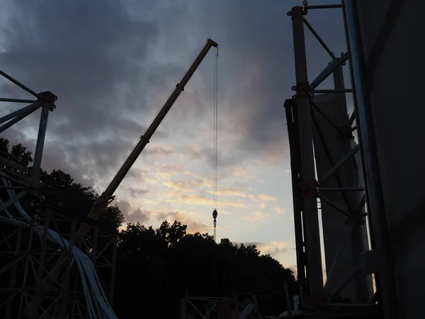 silhouette of a crane, the sky in the shadows, during work, construction industry, workplace