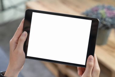 Oturma odasındaki kanepede siyah tableti tutarken yakın plan..