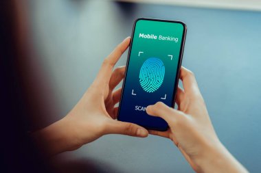 Hands holding smartphone and show the fingerprint scanner screen to access online banking.	