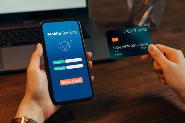 Kadın elleri elinde kredi kartı olan akıllı telefondan cep telefonu bankacılığı kullanıyor ve giriş uygulaması için şifre giriyor.
