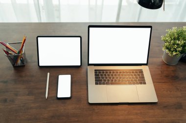 Siyah dijital dizüstü bilgisayar ve ahşap masadaki tabletli akıllı telefon..