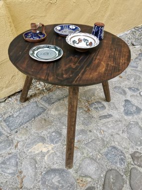 Eski ahşap masa, eski tabaklarla dolu yemek masası.