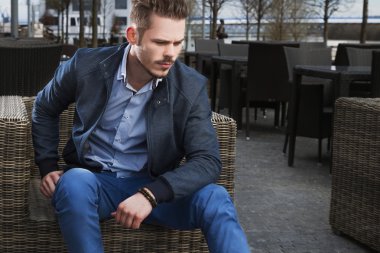 Rattan sandalye üzerinde oturan adam