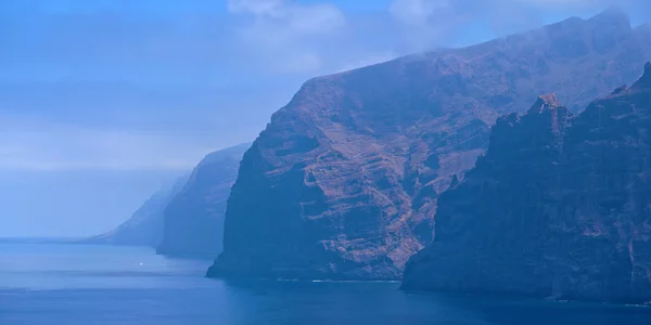 Cliffs of the Giants at Tenerife in morning fog Royalty Free Stock Images