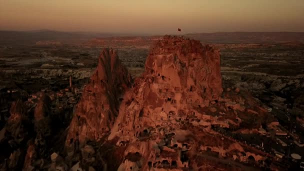 드론이 카파도키아의 우키 사르 산에 있는 터키 국기를 석양에 바라본다 — 비디오