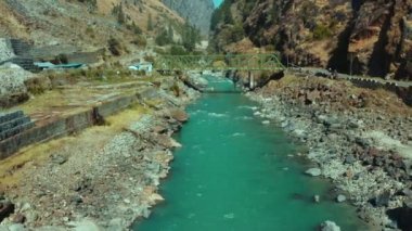 Güzel Bhagirathi Nehri küçük yeşil köprünün altındaki küçük kayaların arasından akar ve Uttarkashi, Uttarakhand, India.Aerial manzara Mavic 2 Pro