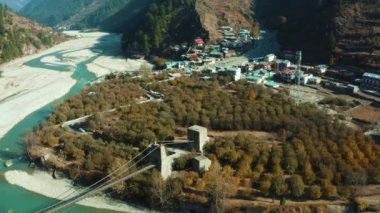 Hindistan 'ın Uttarkashi kentindeki Harsil Köyü' nde dağlarla, köylerle, yeşil ormanlarla ve elma bahçeleriyle çevrili Bhagirathi Nehri üzerindeki köprülerin insansız hava aracı görüntüleri.