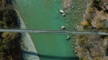 Elma bahçeleri, köyler, ormanlar, Harsil 'deki dağlarla çevrili taşların ve çakıl taşlarının arasından akan Bhagirathi nehri üzerindeki köprü manzarası Uttarakhand' da keşfedilmemiş bir vadi.. 