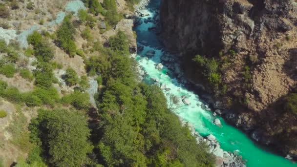 美しいバギラティ川が2つの巨大な山の岩の真ん中を流れ 石を通過し インドのウッタラーカンド州ウッタラーカンドの緑の木々や森に囲まれています — ストック動画