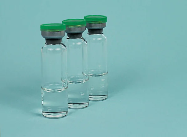 glass jars with a green lid for medicines are placed one after the other. medical jar for the drug. for chemical liquid substances.