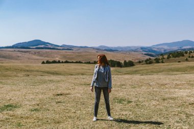Kuru bir dağ tarlasında poz veren genç bir kadın