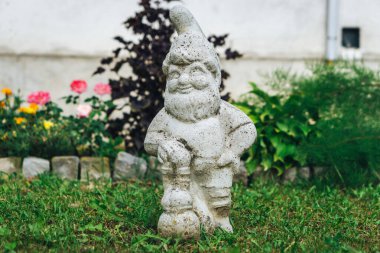 Arka bahçede beton cüce heykel