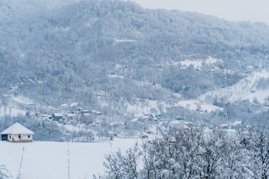 Karlı tepenin üstünde terk edilmiş bir ev.