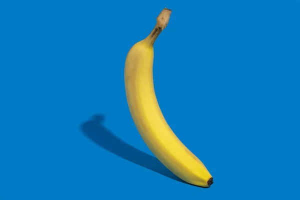 Banana Sobre Fundo Azul Escuro Tiro Lateral Sombra Encaracolada Conceito — Fotografia de Stock