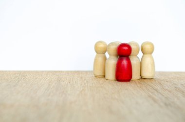 Tahta figürler arasında yerleştirilmiş kırmızı ahşap figür içerik kavramını temsil ediyor.