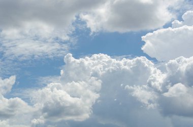 Işıl ışıl bulutlar ve ışık huzmeleri ile derin mavi gökyüzü umudu ve ruhsal yenilenmeyi simgeliyor.