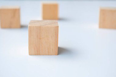 Close up of wooden cubes isolated from each other on white background with customizable space for text