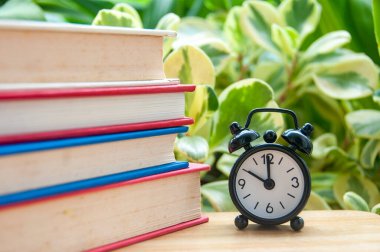 Yığınlanmış kitapların doğa arkaplanı ile kapatılması metin veya fikirler için özelleştirilebilir alan ile öğrenmeyi sembolize eder