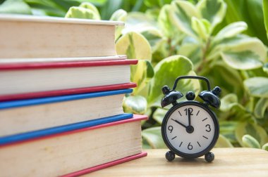 Yığınlanmış kitapların doğa arkaplanı ile kapatılması metin veya fikirler için özelleştirilebilir alan ile öğrenmeyi sembolize eder