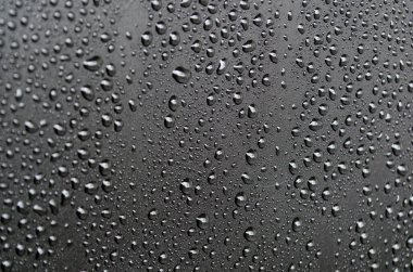 Siyah örtülü arka plandaki su damlacıklarının görüntüsünü kapat. Tasarım ve duvar kağıdı için uygun