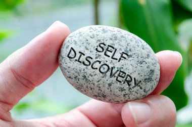 Self Discovery text engraved on dark stone. Life harmony concept