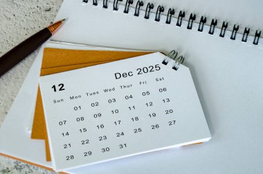 Not defteri ve kalem arkaplanda beyaz Aralık 2025 takvimi. Aralık ay ve yıl sonu kavramı
