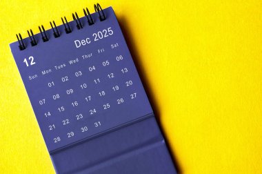 Sarı kapaklı siyah takvime göre Aralık 2025. Takvim kavramı