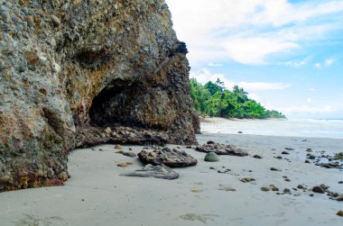 Berrak su üzerinde yeşil bitki örtüsü ve gölgeli uçurum dokularıyla Rocky kıyı şeridi köşesi, Kuala Penyu, Sabah, Malezya