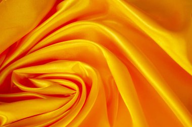 Yumuşak çizgisel kıvrımlı pürüzsüz altın ipekten arkaplan zarif ve soyut bir doku oluşturur