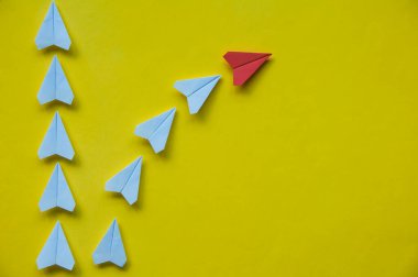 Üst görünüm kağıt uçaklar dikey olarak sarı zemin üzerinde hizalanmış düzen stratejisini ve planlamayı sembolize ediyor