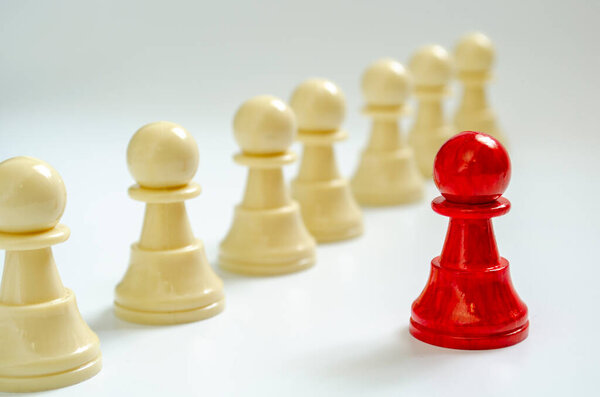 Стоячая красная пешка среди белых пешек, представляющая ответственность за лидерство