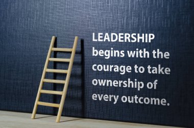 Liderlik, siyah kapaklı ahşap merdivenli cesaret metniyle başlar.