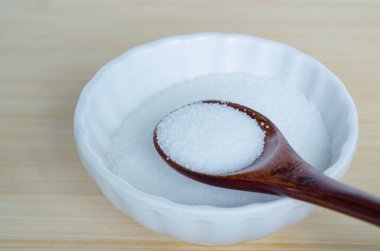 Seramik çanağın içindeki ahşap kaşıkta bulunan tuz kristalleri dikkatli baharatı ve dengeli beslenme yönetimini sembolize ediyor.