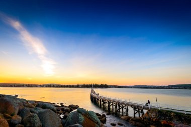 İnsanlar ayak köprüden gün batımında, Victor Harbor, Sa
