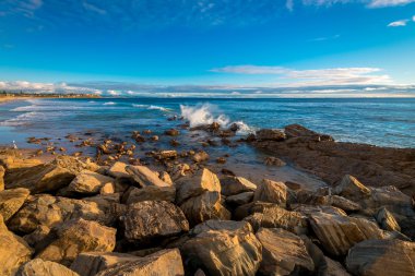 Rashing kayaların içine günbatımı dalgalar