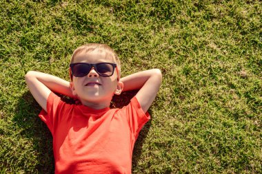 Çocuk çimenlerin üzerinde rahatlatıcı 