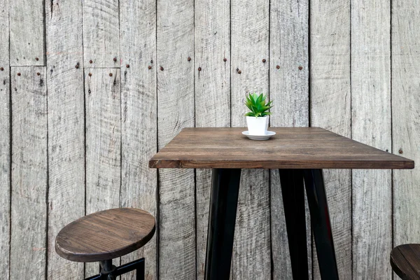 Vintage houten café tafel met een groene bloem bovenop — Stockfoto