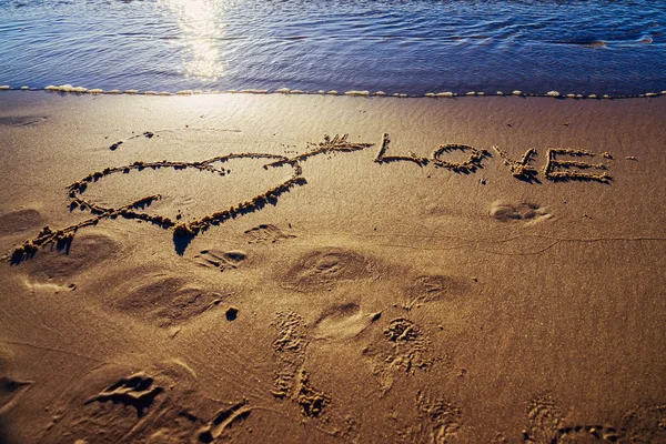 Coeur et flèche dessinés sur sable — Photo