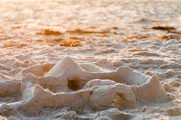 Château de sable sur la plage au coucher du soleil — Photo