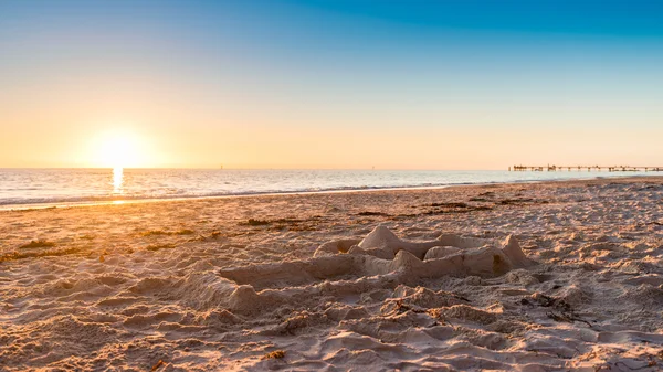 Gün batımında sahilde kum kale — Stok fotoğraf