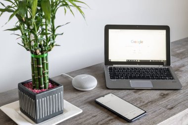 Adelaide, Avustralya - 7 Temmuz 2019: HP dizüstü bilgisayarı ile Google Home Mini Windows 10 ve cep telefonu yan yana kurulmuş