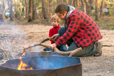 Baba ve oğul, Güney Avustralya 'daki Kuitpo' da kamp ateşi için odun testeresiyle odun kesiyorlar.