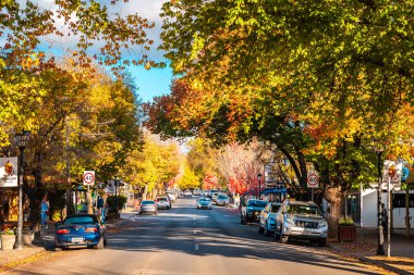Adelaide Hills, Güney Avustralya - 24 Nisan 2021: Hahndorf Main caddesi manzarası Sonbahar sezonunda gün batımında mağazalar ve kafeler boyunca yürüyen insanlarla birlikte